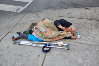 Toronto, Kanada-10 Nisan 2019: Toronto şehir merkezinde Nathan Phillips Meydanı yakınlarında evsiz bir adam yatıyor