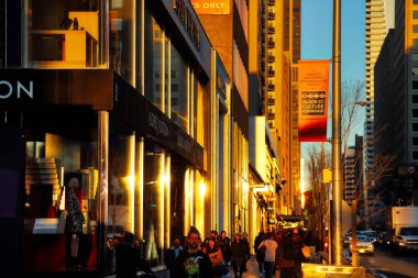 Toronto, Ontario, Kanada-20 Mart 2018: Toronto şehir merkezi. Gün batımında Yonge ve Bloor kavşağında moda dükkanları olan körfez caddesi