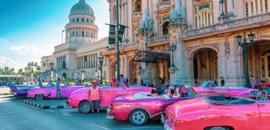 Havana, Küba: Gran Havana tiyatrosu önündeki Paseo del Prado caddesinde Ulusal Kongre Binası (El Capitolio) yakınlarında turistleri bekleyen klasik renkli taksiler