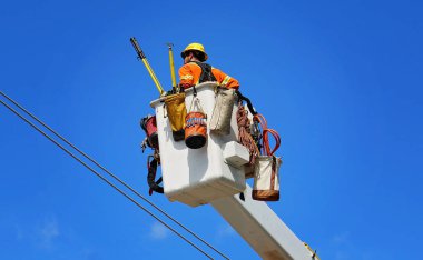 İnşaat işçileri elektrik hatlarını onarıyor. 