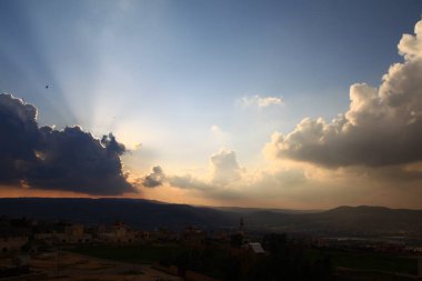 Arap şehri üzerinde bulutlar ile Gün batımı gökyüzü
