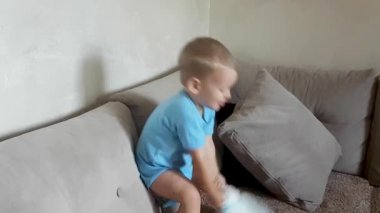 Sevimli 2 yaşındaki çocuk yardım almadan bebek bezi çekmeye çalışıyor.