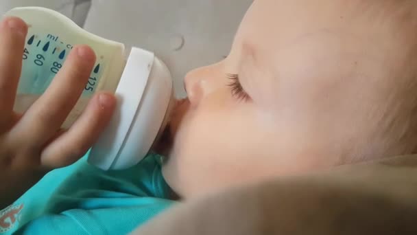 Ragazzo di due anni che beve latte al cioccolato dalla bottiglia, Primo piano — Video Stock