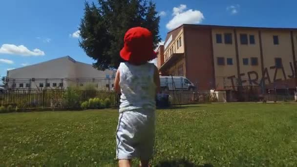 Po dwóch latach chłopiec spaceruje w podwórku z plastikową butelką — Wideo stockowe
