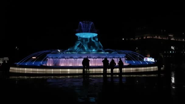 La Valletta, Malta, Le silhouette dei turisti alla Fontana di Tritone illuminata di notte — Video Stock