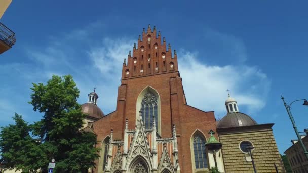 Krakkó, Lengyelország. Külső Szentháromság templom Bazilika alatt nyári égbolt — Stock videók