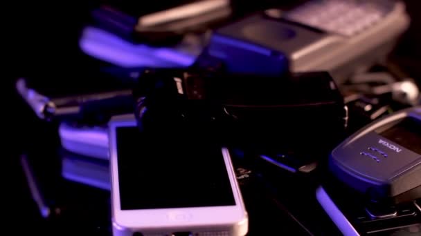 Un mucchio di vecchi telefoni cellulari usati sul display rotante. Nokia, iPhone, Ericsson... — Video Stock