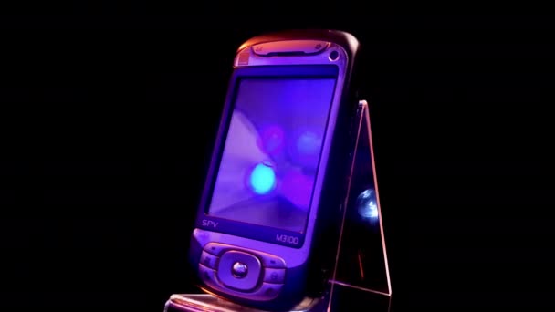 Orange SPV M3100 Смартфон 2000-х годов на вращающемся дисплее, черный фон — стоковое видео