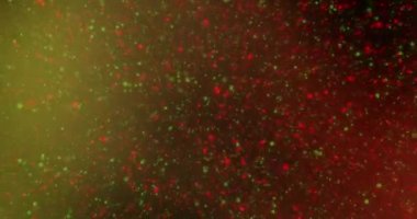 Çerçevenin ortasından izleyiciye sürekli akan kırmızı ve yeşil renkli ışıldayan yıldızlar, değişen kırmızı ve yeşil tonların arka planına doğru uçar.