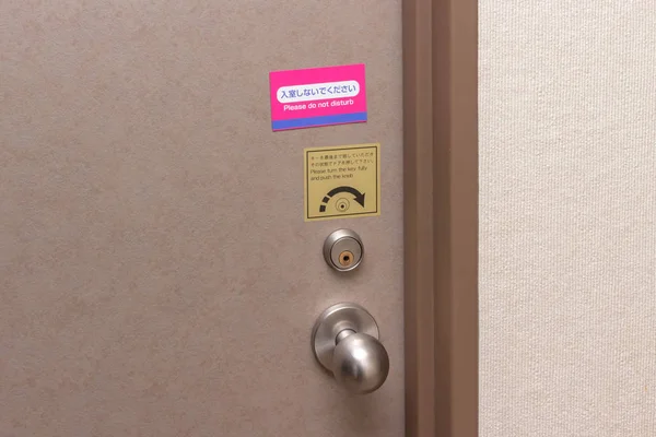 Door of hotel room with sign do not disturb