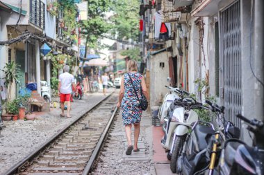 Bir kadın Tren sokakta demiryolu üzerinde yürüyor, Hanoi, Vietnam