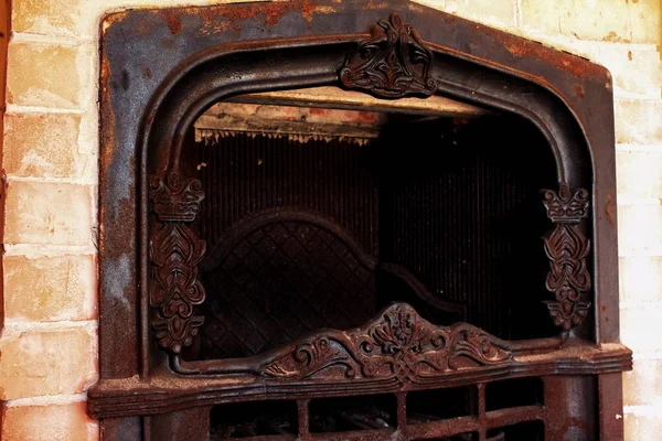 Old fireplace with floral ornaments in an abandoned house