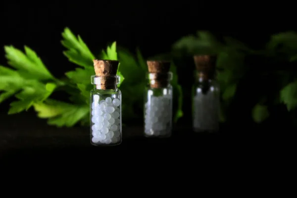 Homeopathy pills in vintage bottles on black background. A bottle of homeopathic remedies