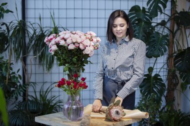 Çiçekçi bir buket yapar.