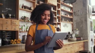 vrouwelijke eigenaar met behulp van digitale tablet in café