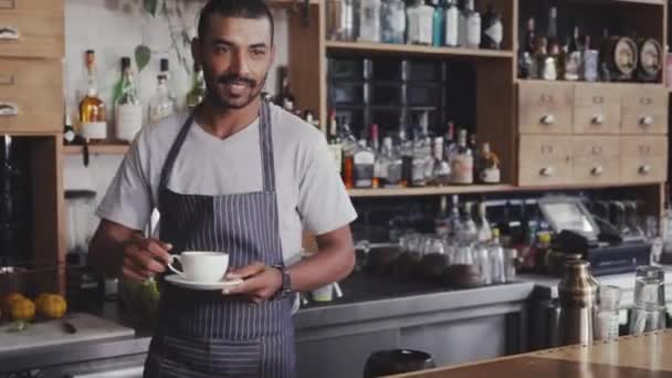 Barista biedt koffie aan de klant in café — Stockvideo