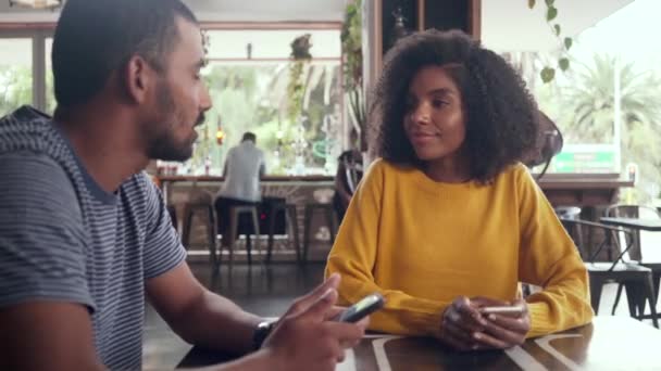 Feliz joven pareja sentada en la cafetería — Vídeo de stock