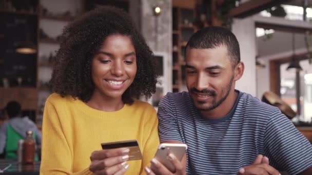 Paar in einem Café mit Kreditkarte online einkaufen — Stockvideo