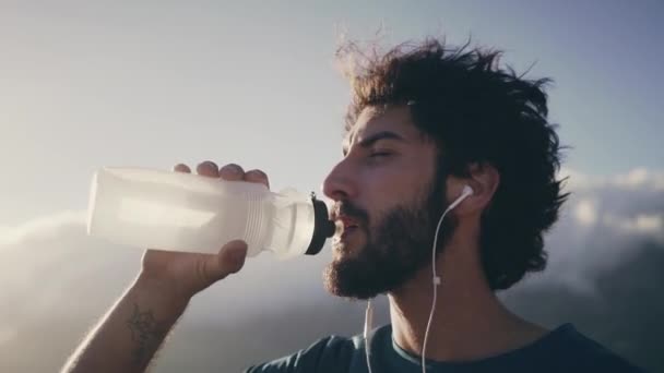 Hombre atleta beber agua de la botella — Vídeo de stock