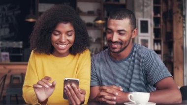 Genç çift cep telefonu ve gülerek video izlerken