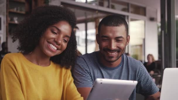 Jeune couple dans un café en utilisant une tablette numérique — Video