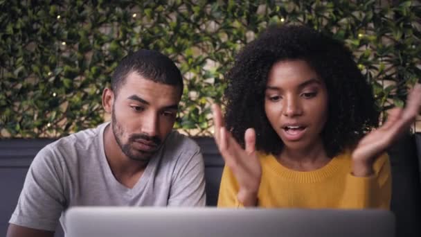 Ανησυχούν νεαρό ζευγάρι χρησιμοποιώντας φορητό υπολογιστή στο καφέ — Αρχείο Βίντεο