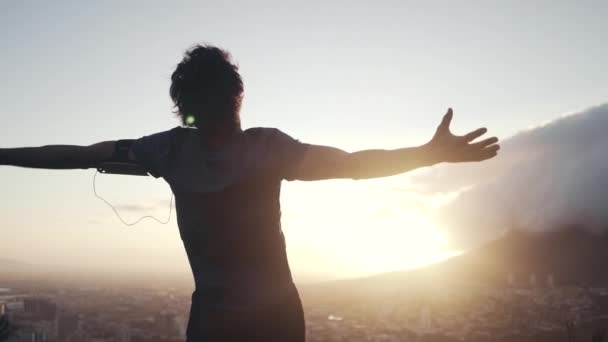 Спортсмен протягивает руки против восхода солнца — стоковое видео