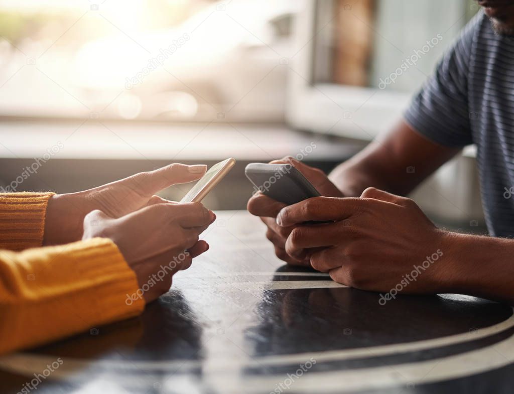 Couple using their mobile phones in cafe