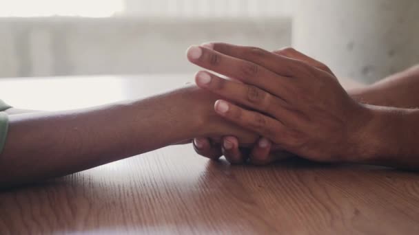 Um casal afetuoso de mãos dadas sobre a mesa — Vídeo de Stock
