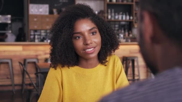 Mosolyogva fiatal nő beszél az emberrel a kávézóban — Stock videók