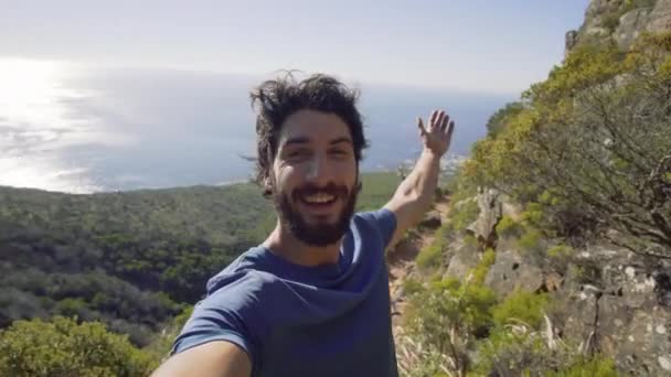 Porträt eines Mannes, der auf einem Berg gegen das Meer steht — Stockvideo