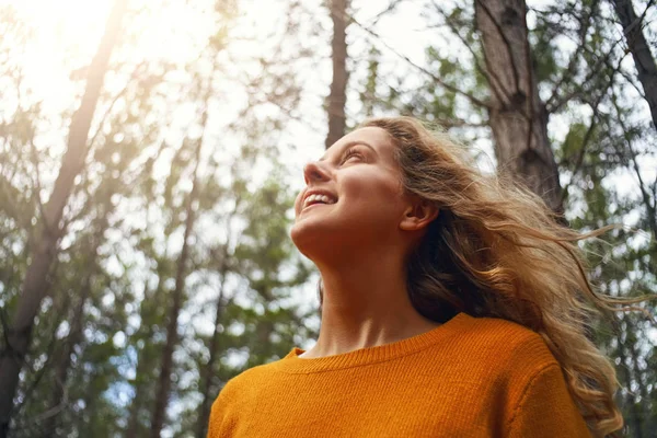 Blonde young woman looking up in the forest — Stock Photo, Image