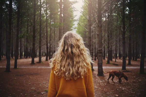 Blonde young woman with her dog in the forest — Stock Photo, Image