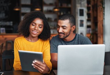 Kafede dizüstü bilgisayar ve dijital tablet ile genç çift