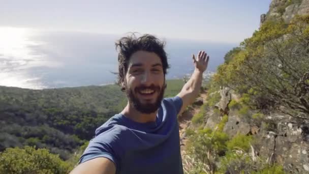 海に対して山の上に立つ男の肖像 — ストック動画