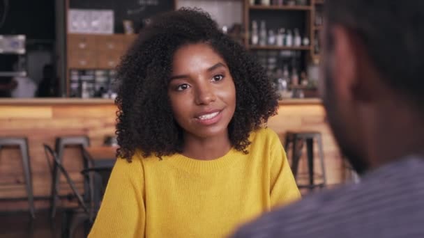 Smiling young woman talking with man in cafe — Stock Video