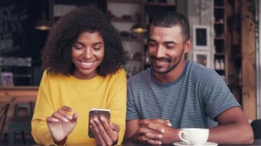 Genç çift cep telefonu ve gülerek video izlerken
