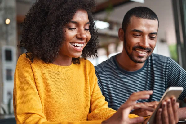 Fröhliches junges Paar blickt lächelnd auf Smartphone — Stockfoto