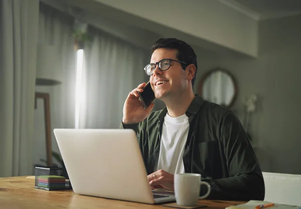 Man praten op een mobiele telefoon en werken op zijn laptop — Stockfoto
