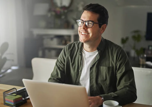 Lachende man met laptop zittend op Bureau op zoek weg — Stockfoto