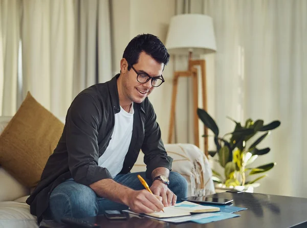 Gelukkige man schrijven op notebook met pen thuis — Stockfoto