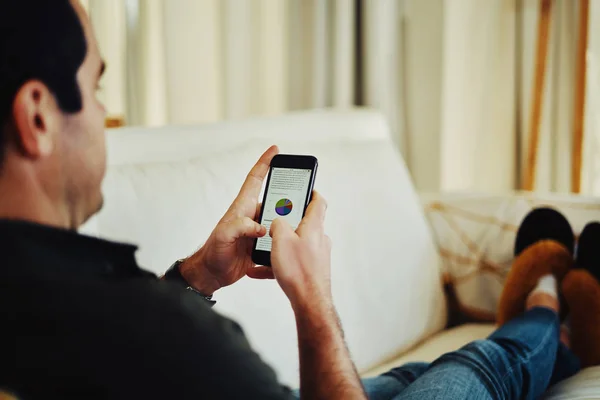 Primer plano de un hombre sentado en un sofá usando un teléfono inteligente — Foto de Stock