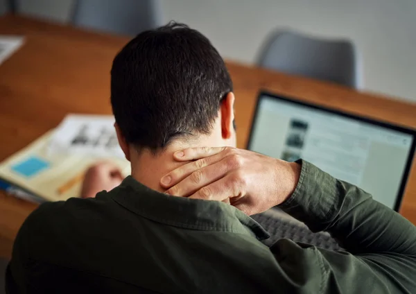 Чоловік страждає від болю в шиї під час роботи на ноутбуці — стокове фото