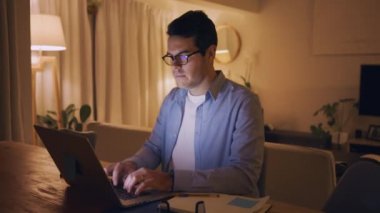 Evde gece geç saatlere kadar dizüstü bilgisayar üzerinde çalışan bir adamın portresi