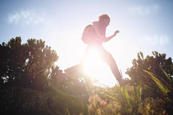 Male hiker running while hiking on sunny day