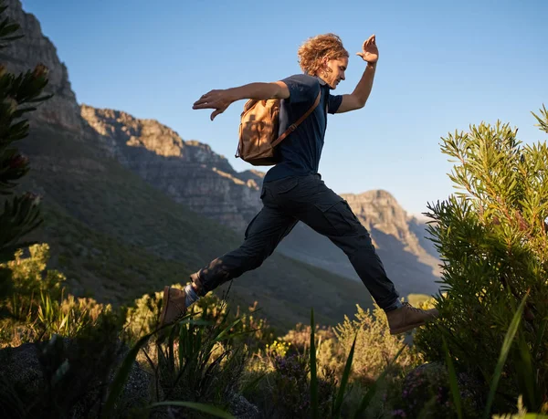 Man springen hoog op een bergwandeling — Stockfoto