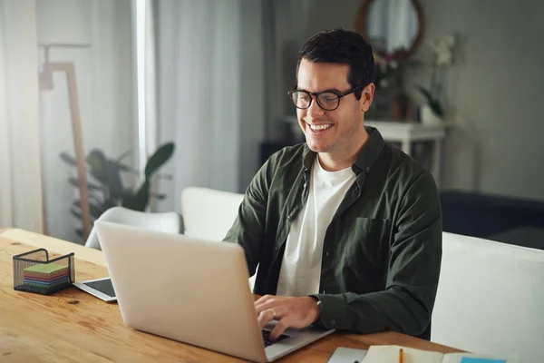 Gelukkige man het dragen van een bril met behulp van laptop thuis — Stockfoto