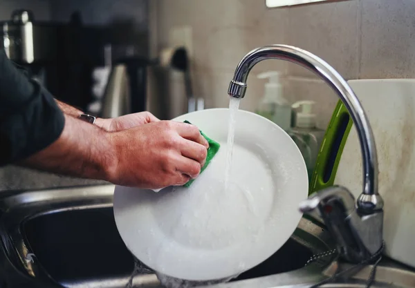 Mans hand washing the dish under the kitchen sink faucet — Stock Photo, Image