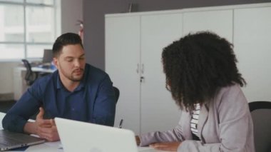 İki farklı genç yöneticiler yeni iş fikirleri tartışıyor ve ofiste evrak üzerinde birlikte çalışıyor