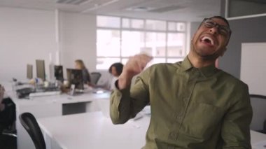 Arka planda çalışan iş arkadaşlarının önünde işyerinde gülen afrikalı genç bir kurumsal işadamının portresi